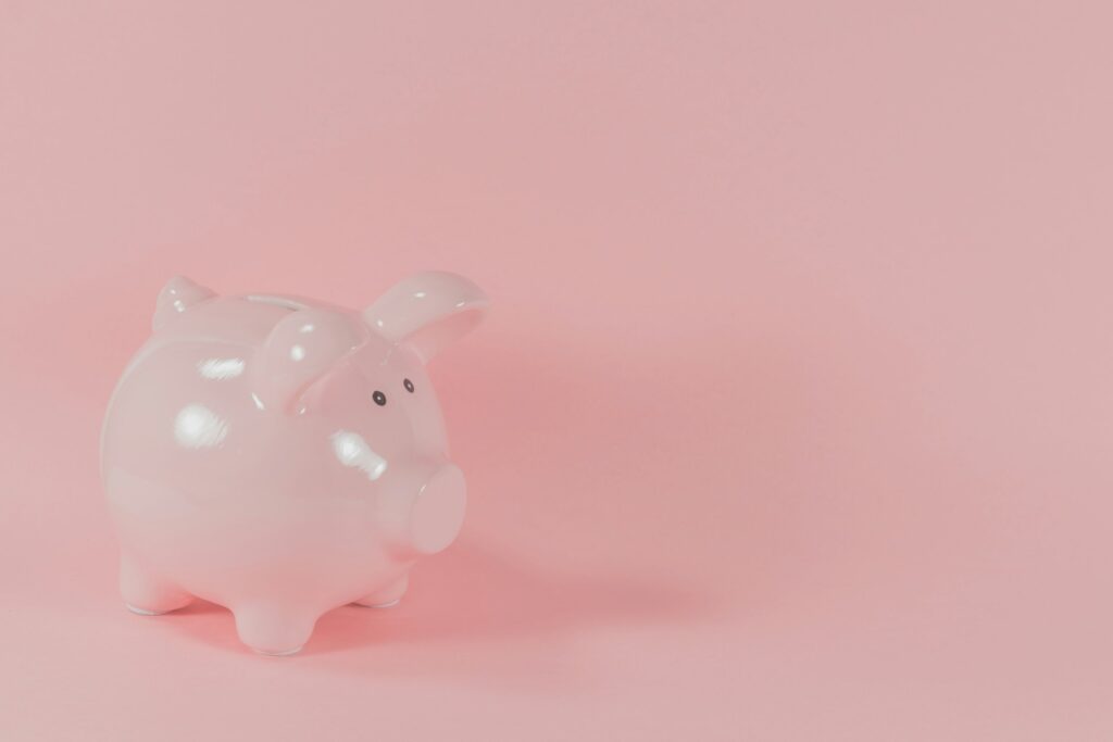 ピンクの背景に置かれた豚の貯金箱