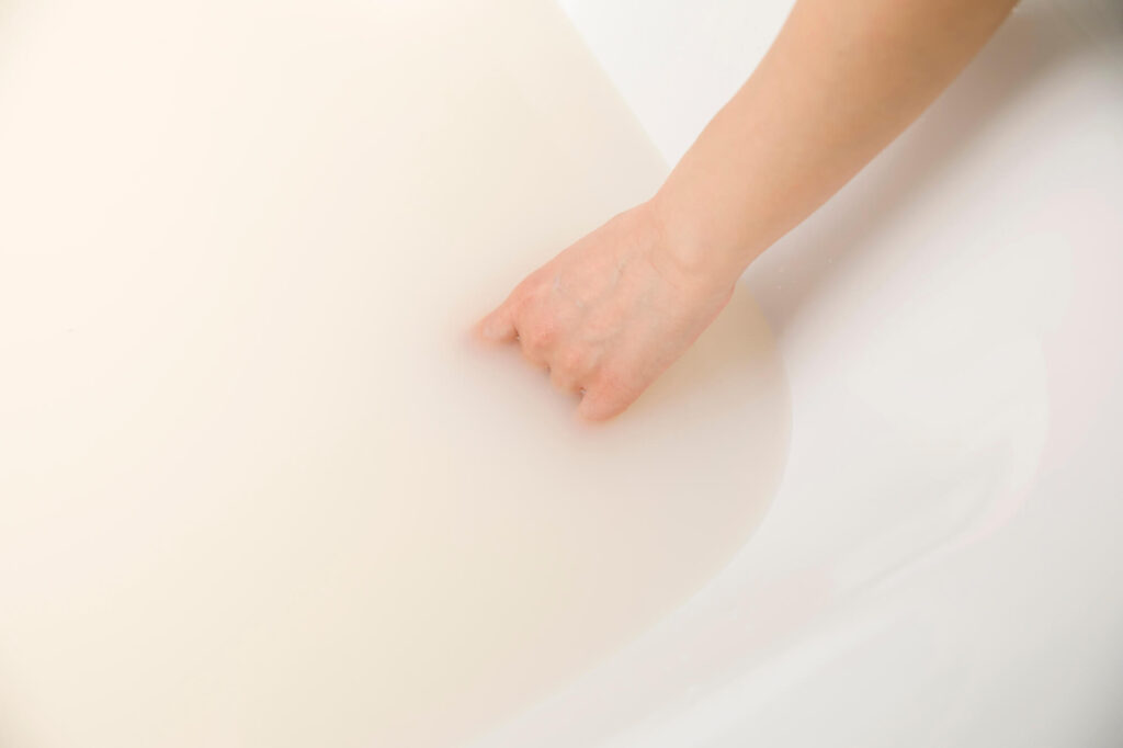 豆乳風呂の白濁したお湯に手を入れる様子